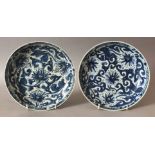 A PAIR OF CHINESE KANGXI PERIOD BLUE & WHITE SHIPWRECK PORCELAIN PLATES. 22cm diameter.