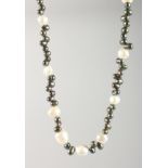A BLACK & WHITE PEARL NECKLACE with gold fastener.