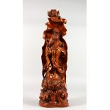 A CHINESE CARVED WOOD FIGURE OF GUANYIN on a lotus base. 20.5ins high.