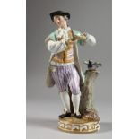 A MEISSEN PORCELAIN FIGURE OF A YOUNG MAN standing beside a tree stump with a bird. Cross swords