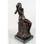 A BRONZE FIGURE OF A SEATED FEMALE NUDE, seated on a rock, her hands held to her mouth, calling out,