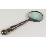 AN OLD BRASS HANDLED MAGNIFYING GLASS.