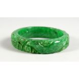 A CHINESE CARVED APPLE GREEN JADE BANGLE. 2.75ins diameter.