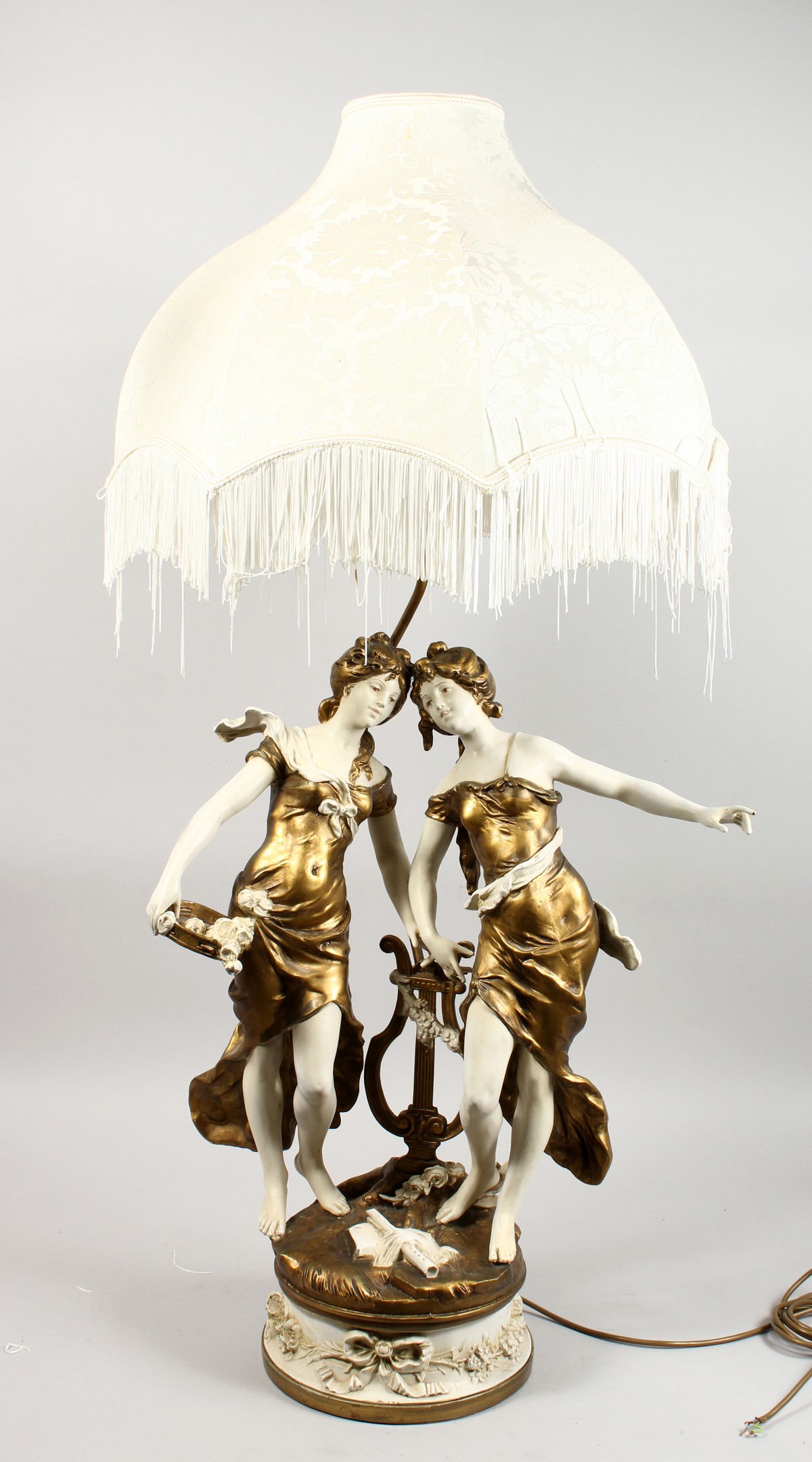 AN ORNATE ART NOUVEAU STYLE PAINTED CAST METAL TABLE LAMP, modelled as two young ladies standing