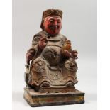 A CHINESE CARVED AND PAINTED WOOD SEATED FIGURE. 9ins high.