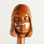 A 20TH CENTURY WALKING STICK, the handle carved as a head of a girl. 92cms long.