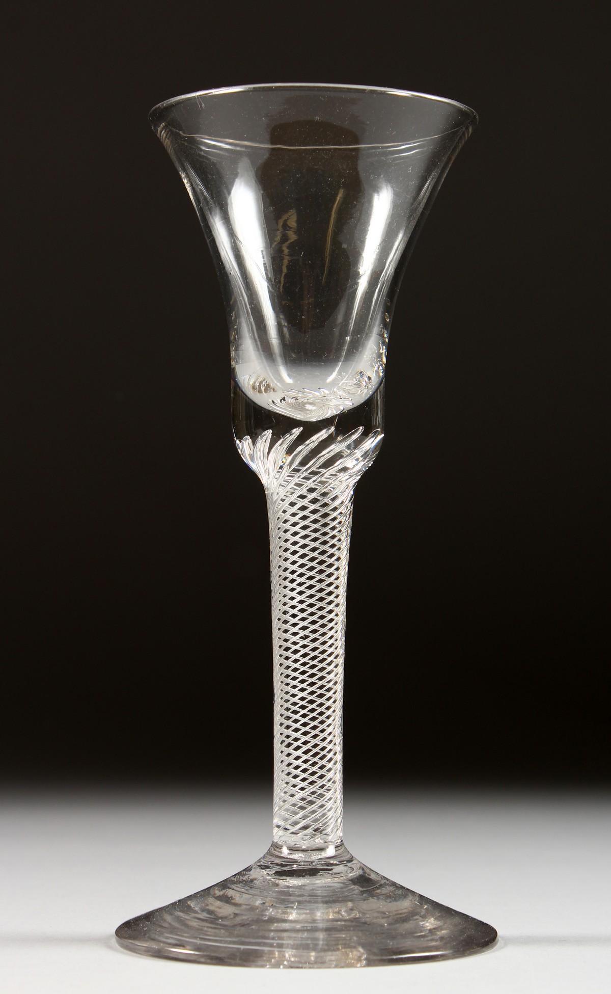 A GEORGIAN WINE GLASS with inverted bell shaped bowl and air twist stem. 6.5ins high.