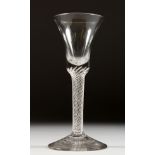 A GEORGIAN WINE GLASS with inverted bell shaped bowl and air twist stem. 6.5ins high.