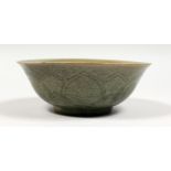 A CHINESE CELADON GLAZED PORCELAIN BOWL with moulded decoration. 7ins diameter.