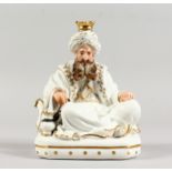 A FRENCH JACOB PETIT PORCELAIN FIGURE OF A SEATED TURK, white glaze decorated in gilt, his head as a