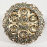 A RUSSIAN SILVER AND ENAMEL CIRCULAR SEDER PLATE with scrolled border, six applied dishes with