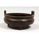 A BRONZE TWIN HANDLED TRIPOD CENSER with Arabic script. 6ins diameter.