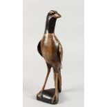 A NAIVE WOODEN CARVED FOLK ART BIRD. 11.5ins high.