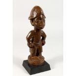 A YORUBA CARVED WOOD TRIBAL FIGURE. 11ins high.