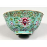 A CHINESE TURQUOISE GLAZED PORCELAIN BOWL, enamel decorated with flowers. 6.5ins.
