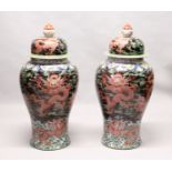 AN IMPRESSIVE PAIR OF FLOOR STANDING CHINESE TEMPLE JARS AND COVERS, black ground decorated with