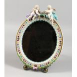 A GOOD 19TH CENTURY MEISSEN OVAL MIRROR with cupid holding a garland. Bevelled mirror 9ins x 7ins.