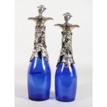 A SMALL PAIR OF BRISTOL BLUE GLASS BOTTLES with plated fruiting vines, mounts and corks.