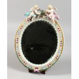 A GOOD 19TH CENTURY MEISSEN OVAL MIRROR with cupid holding a garland. Bevelled mirror 9ins x 7ins.
