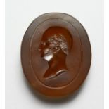 AN INTAGLIO CARVED AMBER GLASS BUST OF A MAN, in the Roman style. 2ins high.