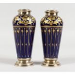 A PAIR OF LIMOGES SMALL PORCELAIN GILT DECORATED BLUE GROUND VASES, with silver mounts. 4.5ins