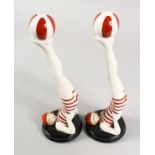 A PAIR OF RED AND WHITE ART DECO STYLE SWIMMERS juggling a ball. 11ins high.