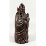 A CHINESE CARVED WOOD FIGURE OF A BEARDED MAN holding a child. 15.5ins high.