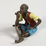 A VIENNA STYLE COLD PAINTED BRONZE OF A SEATED MAN SMOKING A PIPE. 2.5ins high.