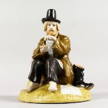 A RUSSIAN STYLE PORCELAIN FIGURE OF A TRAMP sitting, holding a slice of bread, his boots behind