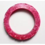 A CHINESE CARVED PINK JADE BANGLE. 3.25ins diameter.