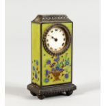 A MINIATURE SILVER CLOCK, with green ground enamel decorated body. 2.5ins high.