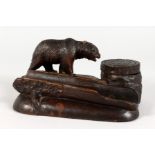 A GOOD BLACK FOREST CARVED WOOD INKSTAND AND PEN TRAY, carved with a bear. 7ins long.