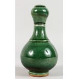 A SMALL CHINESE GREEN GLAZED PORCELAIN GARLIC NECK VASE. 7ins high.