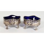 A GOOD PAIR OF GEORGE III PIERCED OVAL SALTS with sapphire blue liners on claw feet. London 1786.