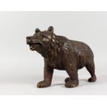 A GOOD BLACK FOREST POTTERY STANDING BEAR. 13ins long.
