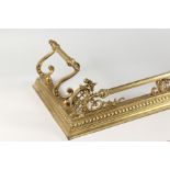 AN ORNATE BRASS FENDER. 59in long x 14.5ins deep.