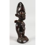 A CARVED WOOD TRIBAL FIGURE with shell necklace. 8ins high.