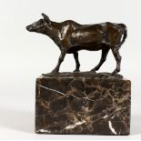 A SMALL BRONZE OF A COW, mounted on a marble plinth. 5.5ins long.