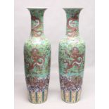 AN IMPRESSIVE PAIR OF CHINESE PORCELAIN FLOOR STANDING VASES, green ground, painted with dragons.