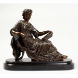 A CLASSICAL BRONZE OF A SEATED YOUNG LADY reading a book, on a wooden base. 10ins long.