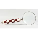 A MAGNIFYING GLASS with checked handle.