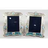 A PAIR OF LARGE SILVER AND ENAMEL UPRIGHT PHOTOGRAPH FRAMES with blue birds. 12.5ins x 10ins.
