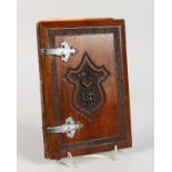 A CARVED WOOD ALBUM with crest and silver hinges, inside are four Victorian stamps.