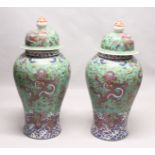 AN IMPRESSIVE PAIR OF FLOOR STANDING CHINESE TEMPLE JARS AND COVERS, green ground decorated with