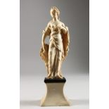 AN 18TH CENTURY CARVED IVORY FIGURE OF A YOUNG FEMALE FIGURE depicting AUTUMN, standing on a plinth.