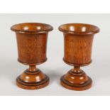 A PAIR OF TURNED TREEN URN SHAPED GOBLETS. 5.75ins high.