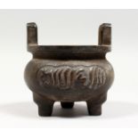 A BRONZE TWIN HANDLED TRIPOD CENSER with Arabic script. 4ins diameter.