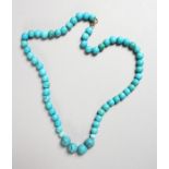 A TURQUOISE BEAD NECKLACE with gold clasp.