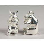 A PAIR OF SEATED PIG SALT AND PEPPERS.