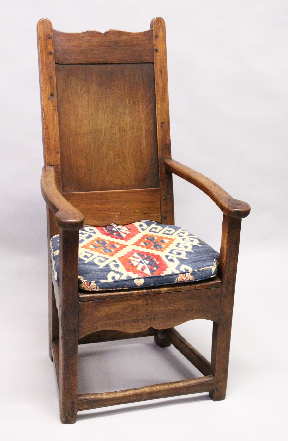 A 17TH / 18TH CENTURY LAMBING CHAIR, possibly fruitwood, with shaped cresting, plain panel back,